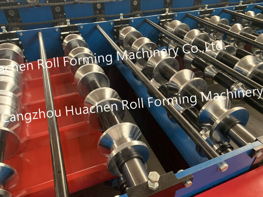 A metal roof panel manufacturing machine for producing tile-shaped corrugated roof panels by rolling process